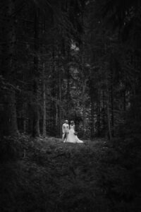 lummigt bröllopsporträtt av ett brudpar i skogen